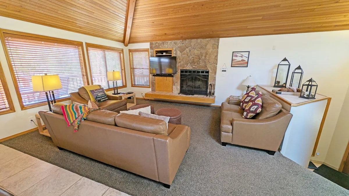 A cozy living and dining area with a fireplace, television, and an inviting seating arrangement. The space is designed for family gatherings, relaxation, and connection, creating a warm, communal environment adjacent to cooking and dining.